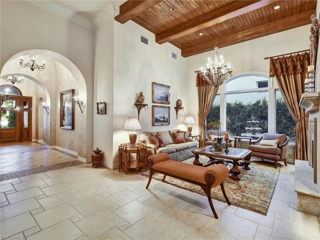 9113 Terrabella Court Naples, FL 34109 - Photo 8 of 47 a living room with furniture a large window and a chandelier