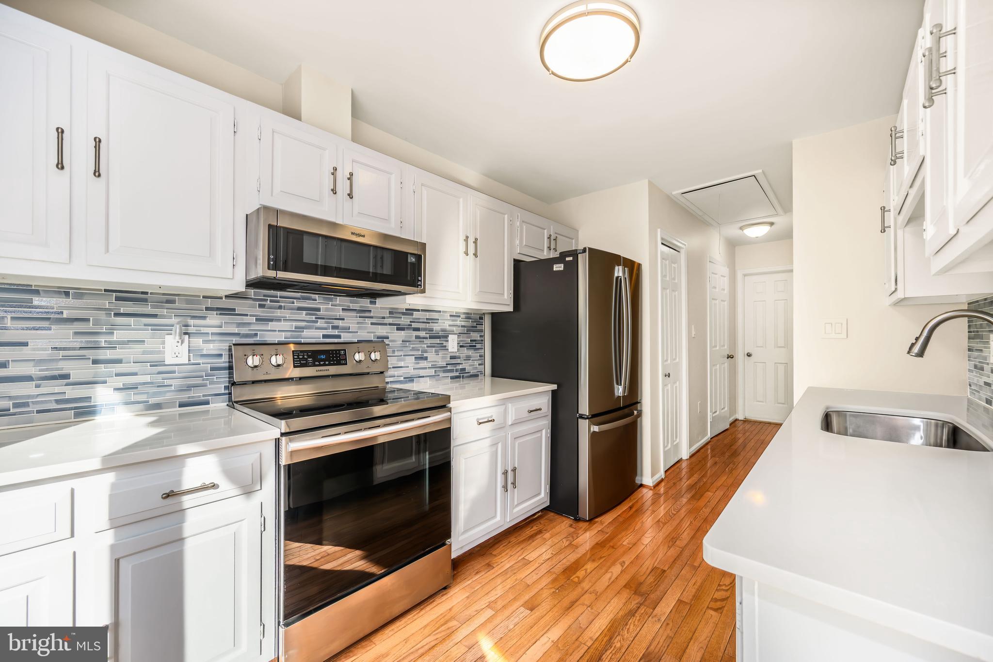 24700 Deepwater Point Drive, Unit 1 St. Michaels, MD 21663 - Photo 17 of 47 a kitchen with a sink stove and refrigerator