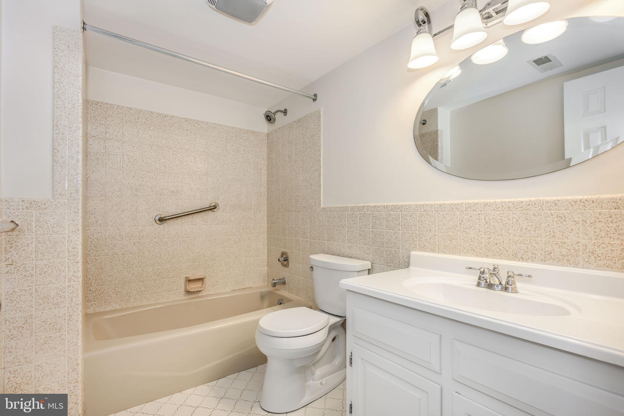 24700 Deepwater Point Drive, Unit 1 St. Michaels, MD 21663 - Photo 26 of 47 a bathroom with a toilet a sink a mirror a bathtub and vanity