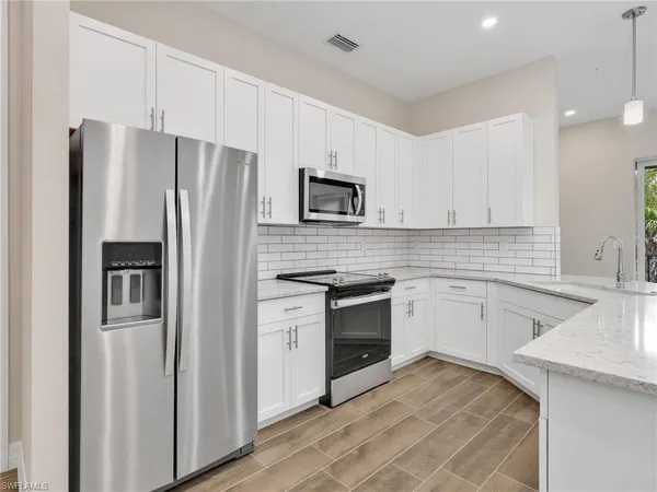 a kitchen with stainless steel appliances granite countertop a refrigerator sink and stove