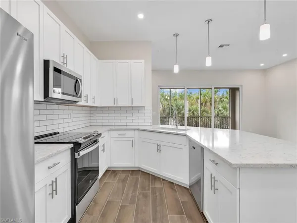 a view of kitchen with stainless steel appliances granite countertop cabinets and wooden floor