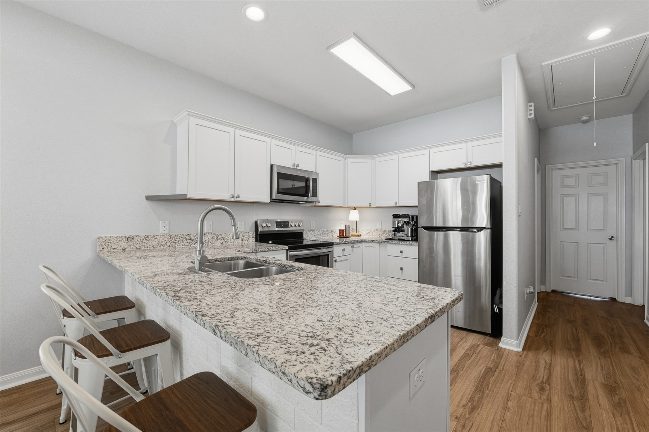 16879 Balmoral Street Montgomery, TX 77316 - Photo 14 of 25 a kitchen with granite countertop a refrigerator a sink a stove a microwave and island