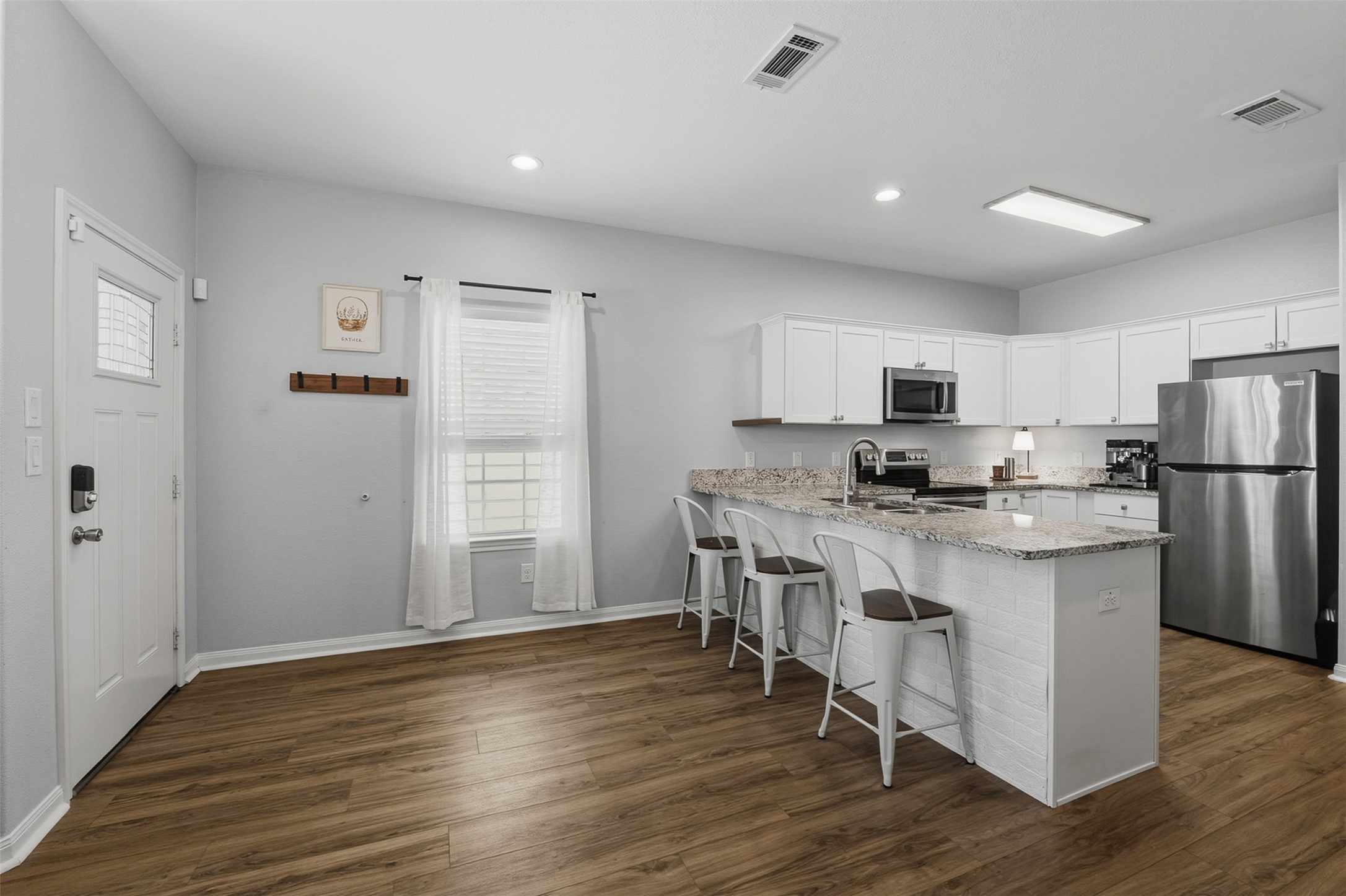 16879 Balmoral Street Montgomery, TX 77316 - Photo 9 of 25 a kitchen with stainless steel appliances a refrigerator a stove a sink dishwasher and a refrigerator with wooden floor