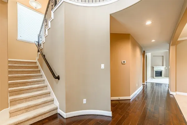 a view of a hallway with wooden floor and staircase