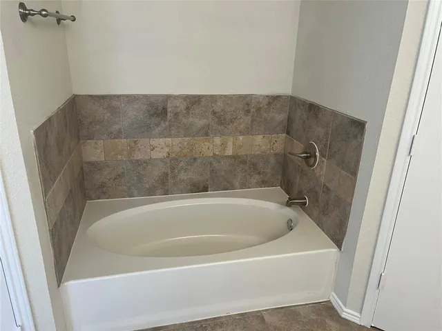 a bathroom with a tub a sink and a shower