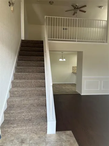 a view of an empty room with wooden floor and a fireplace