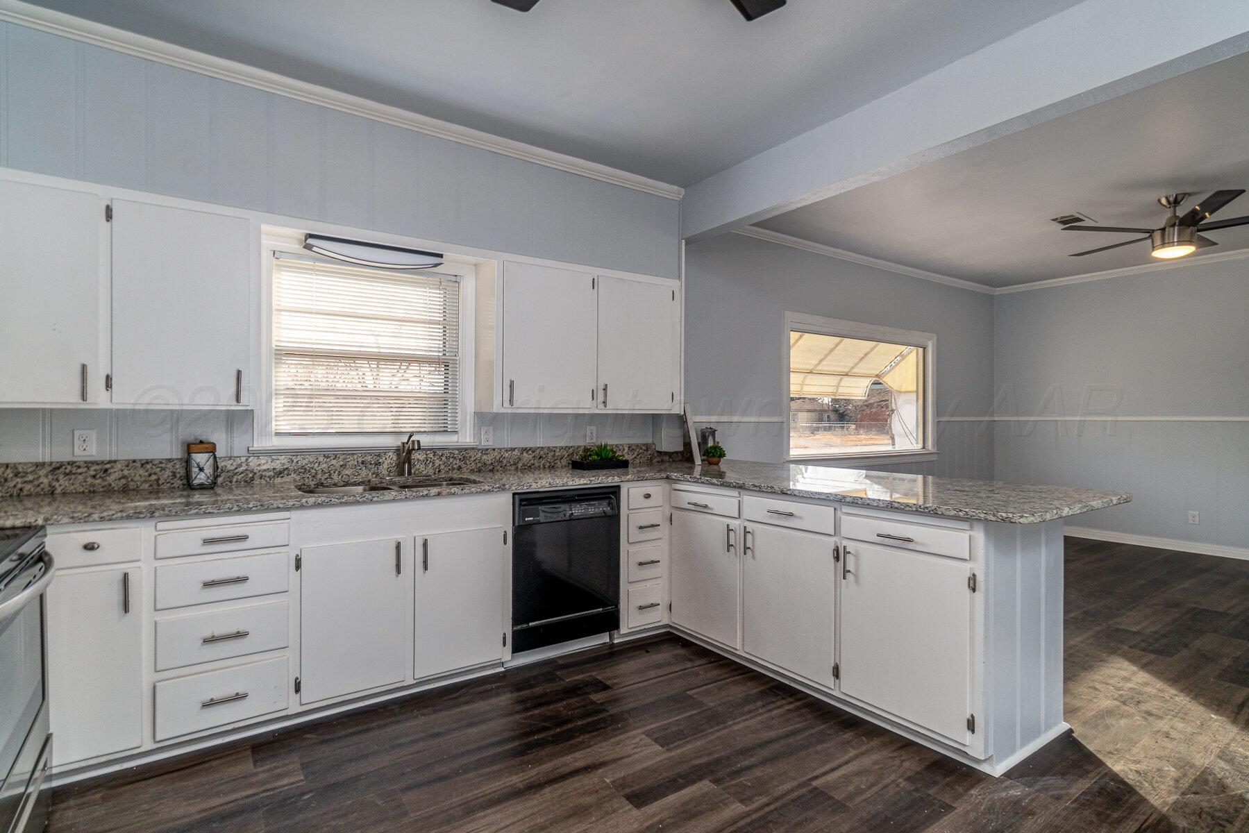 700 21st Street Canyon, TX 79015 - Photo 12 of 30 a kitchen with granite countertop a sink cabinets stainless steel appliances and a window