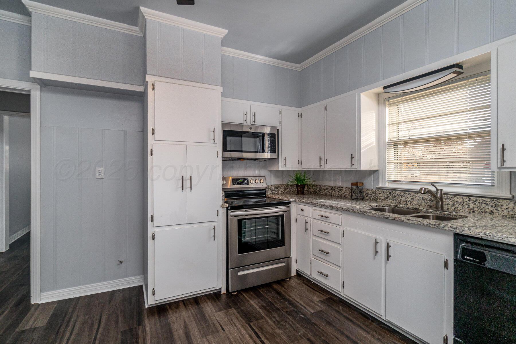 700 21st Street Canyon, TX 79015 - Photo 13 of 30 a kitchen with white cabinets stainless steel appliances and sink