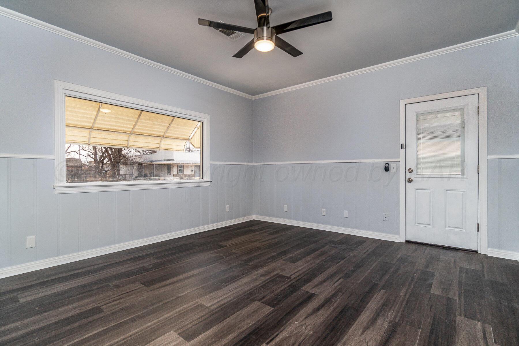 700 21st Street Canyon, TX 79015 - Photo 15 of 30 an empty room with wooden floor chandelier fan and windows