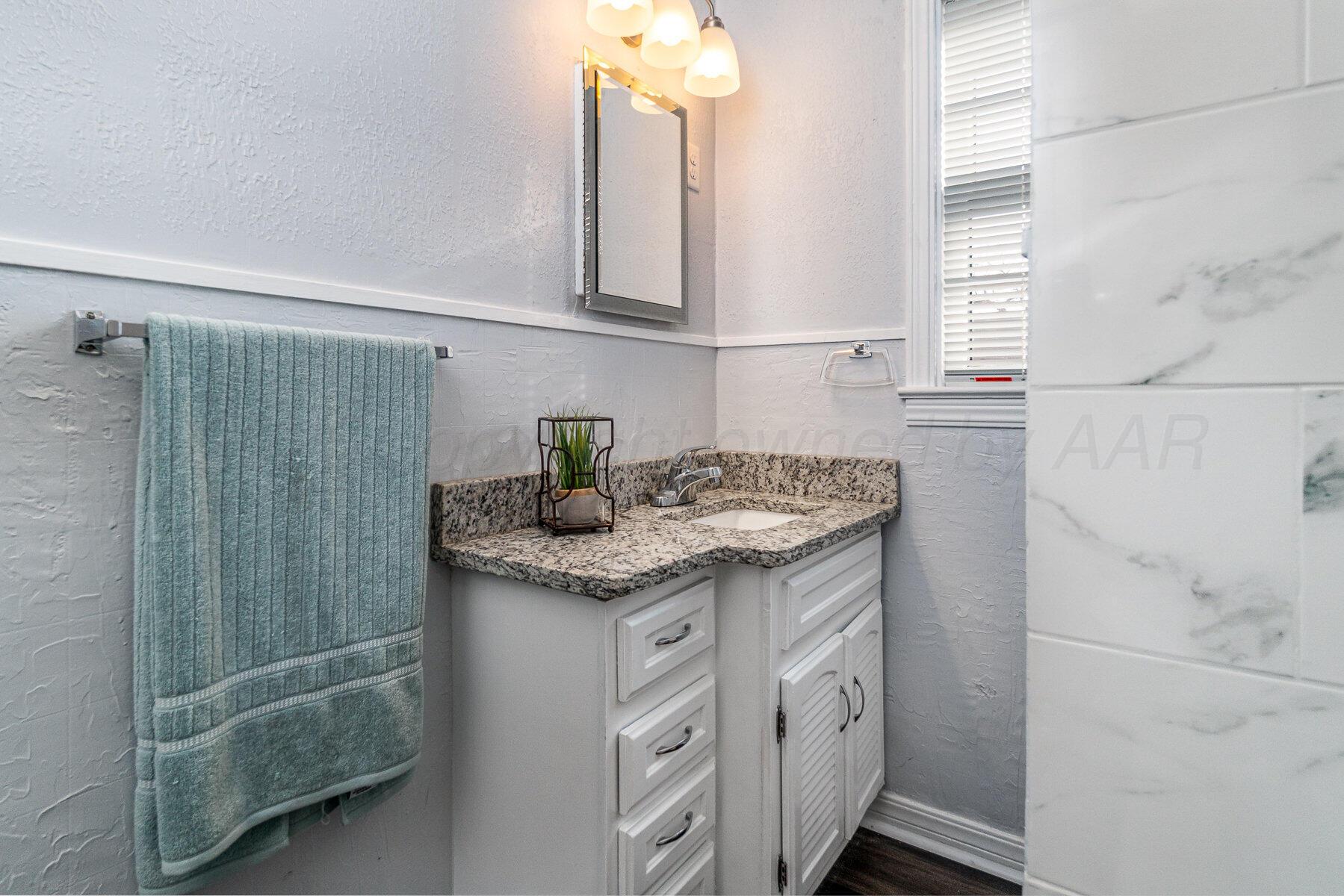 700 21st Street Canyon, TX 79015 - Photo 17 of 30 a bathroom with a granite countertop sink and a mirror