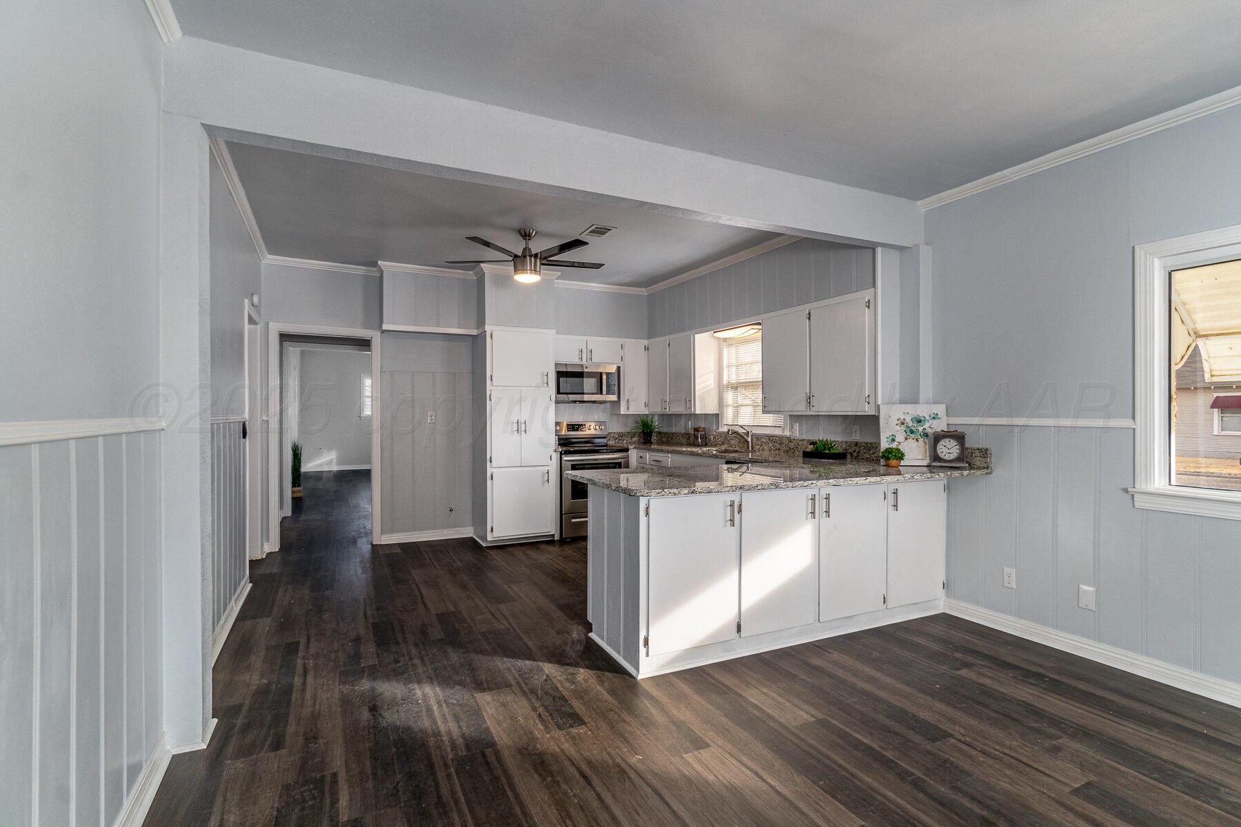 700 21st Street Canyon, TX 79015 - Photo 6 of 30 a kitchen with a refrigerator and white cabinets