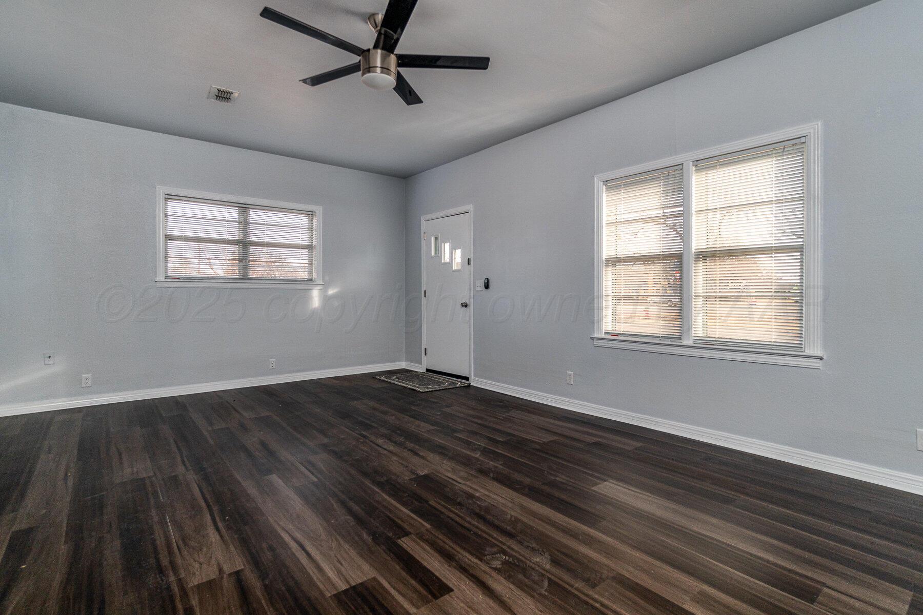 700 21st Street Canyon, TX 79015 - Photo 7 of 30 a view of an empty room with wooden floor and a window