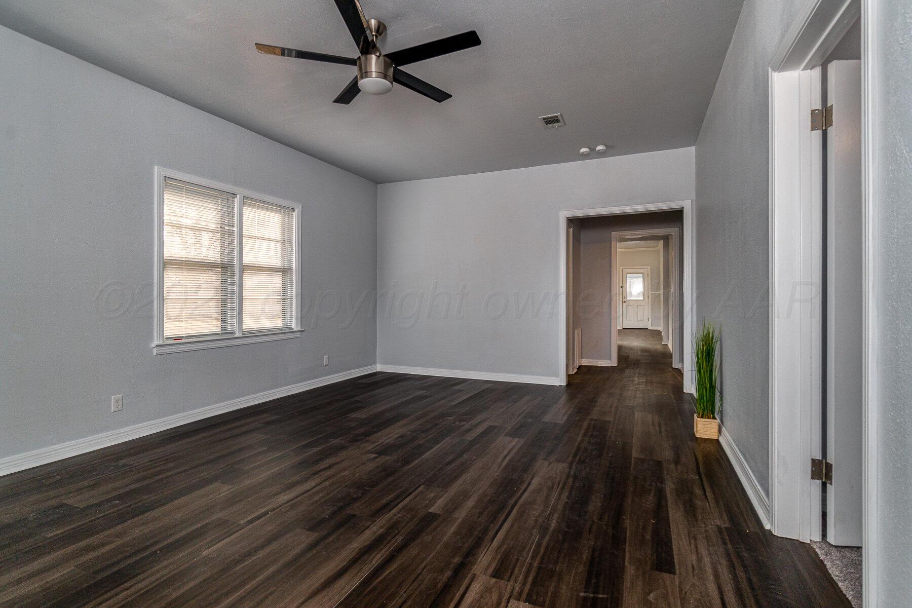 700 21st Street Canyon, TX 79015 - Photo 8 of 30 a view of a room with wooden floor a ceiling fan and windows
