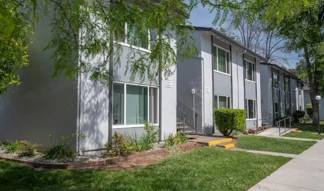 front view of house with a yard and potted plants