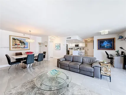 a living room with furniture and a dining table with wooden floor