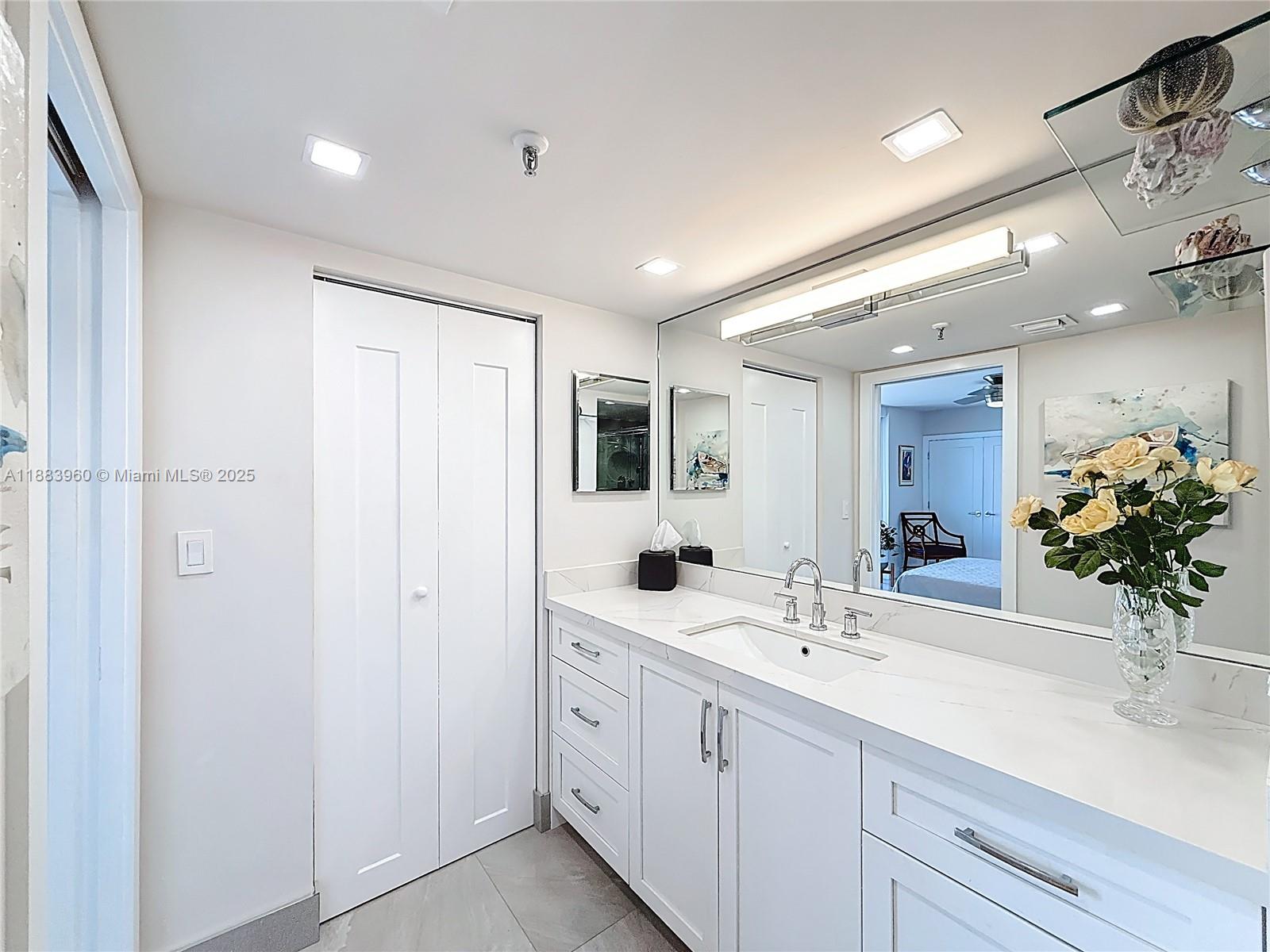 6061 Collins Avenue, Unit 20C Miami Beach, FL 33140 - Photo 17 of 29 a bathroom with a double vanity sink and a mirror
