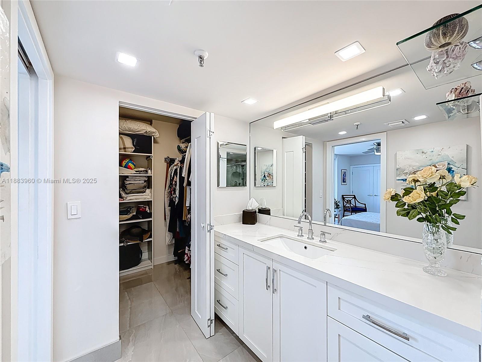 6061 Collins Avenue, Unit 20C Miami Beach, FL 33140 - Photo 18 of 29 a bathroom with a sink a double vanity and a shower