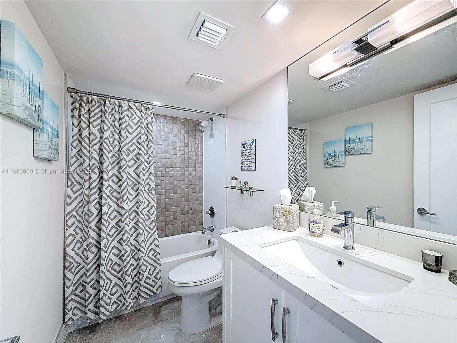 6061 Collins Avenue, Unit 20C Miami Beach, FL 33140 - Photo 21 of 29 a bathroom with a toilet sink shower and mirror