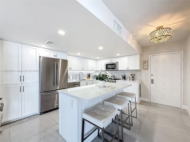 a kitchen with refrigerator and chairs