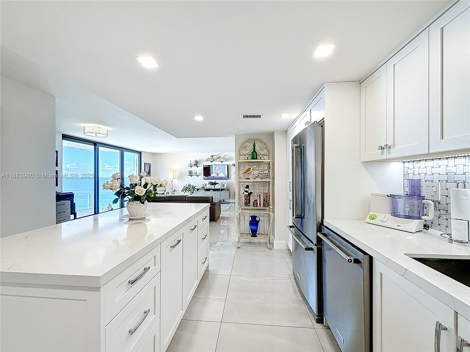 6061 Collins Avenue, Unit 20C Miami Beach, FL 33140 - Photo 8 of 29 a kitchen with counter top space a sink appliances and cabinets