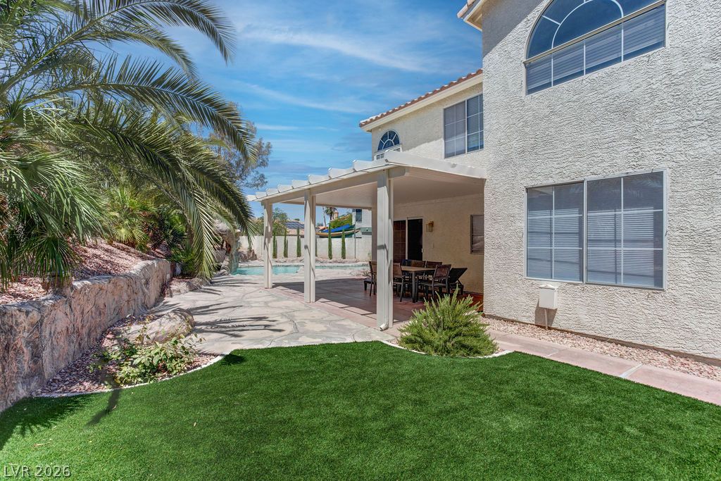 1 Rising Sun Court Henderson, NV 89074 - Photo 40 of 47 An inviting backyard oasis with a covered patio, artificial turf, and refreshing pool.