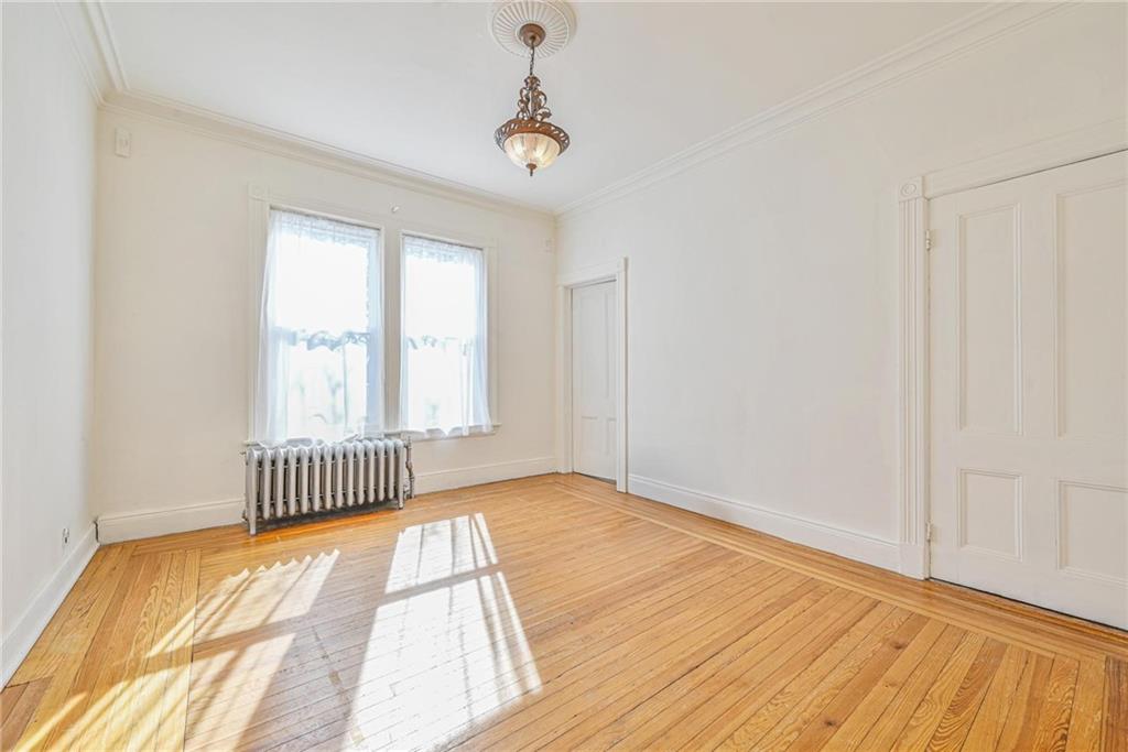 82 Battery Avenue Brooklyn, NY 11228 - Photo 11 of 26 a view of empty room with wooden floor and fan