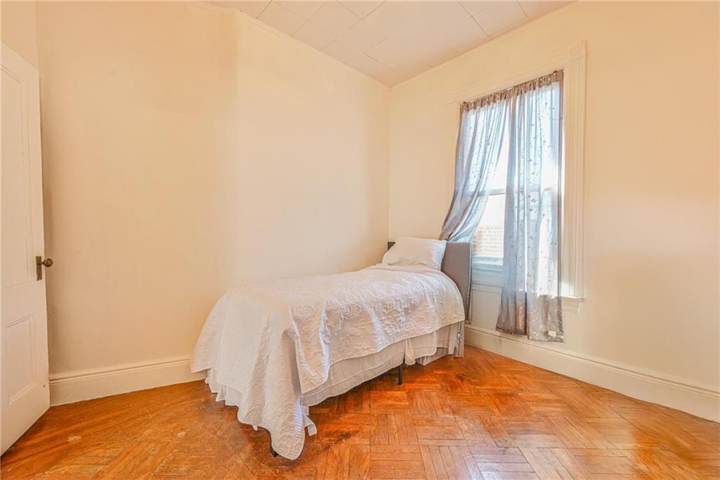 82 Battery Avenue Brooklyn, NY 11228 - Photo 12 of 26 a bed sitting in a bedroom next to a window