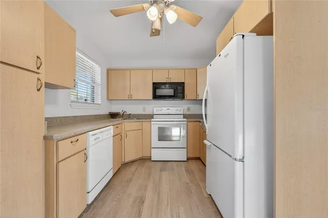 a kitchen with white cabinets and white appliances