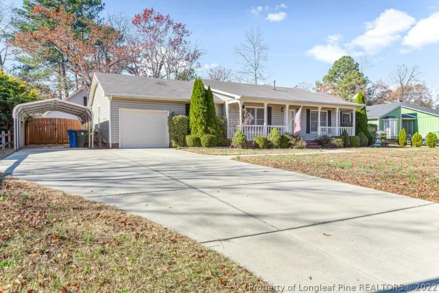 a front view of a house with a yard and potted plants