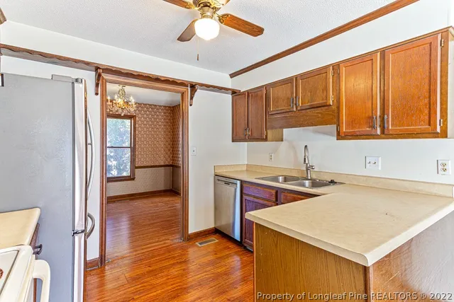 a kitchen with stainless steel appliances granite countertop a sink a stove and a refrigerator