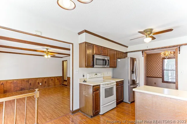 a view of kitchen with stainless steel appliances granite countertop a stove and a sink