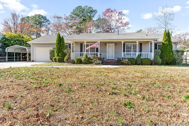 a front view of a house with a yard and potted plants