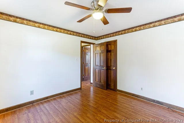 a view of empty room with wooden floor