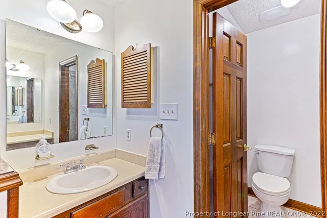 a bathroom with a sink vanity mirror and toilet
