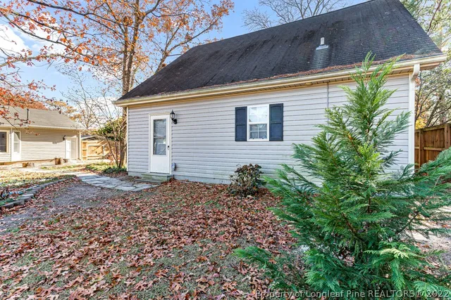 a view of a backyard with plants and large tree