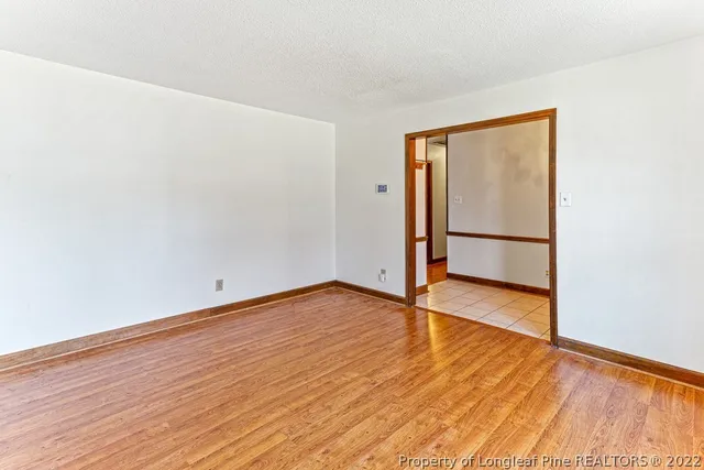 an empty room with wooden floor and door