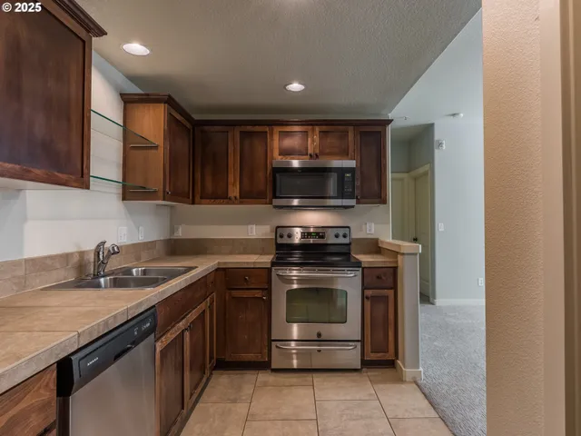 a kitchen with stainless steel appliances granite countertop a sink stove and microwave