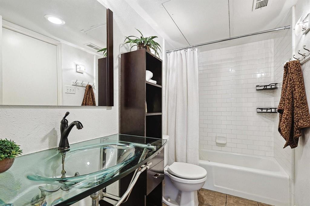 15914 Club Crest Drive, Unit 1112 Dallas, TX 75248 - Photo 32 of 35 a bathroom with a sink a toilet and shower