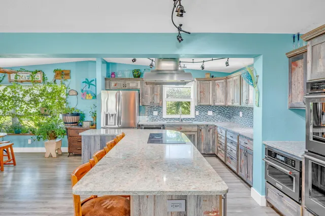 a living room with furniture kitchen view and a large window