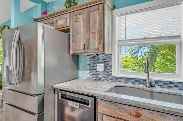 a kitchen with stainless steel appliances granite countertop a refrigerator and a stove top oven