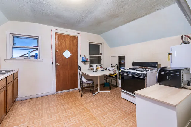 a kitchen with a stove a refrigerator and a dining table