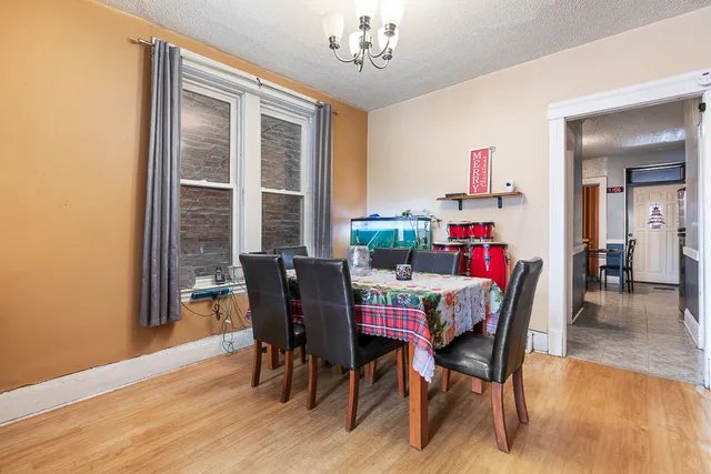 a dining room with furniture a chandelier and wooden floor