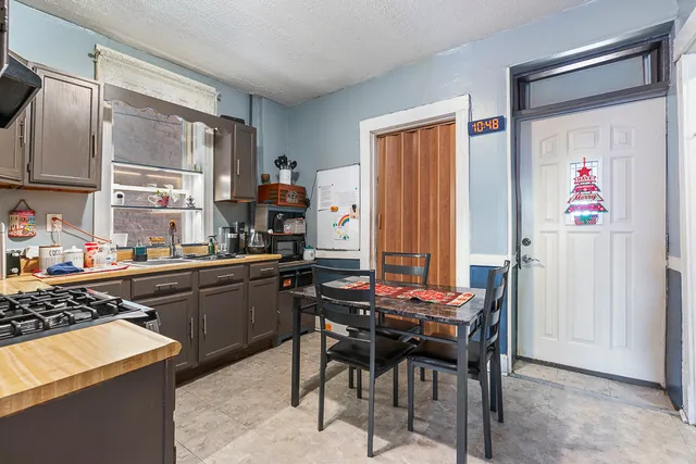 a room with stainless steel appliances kitchen island granite countertop furniture and a refrigerator