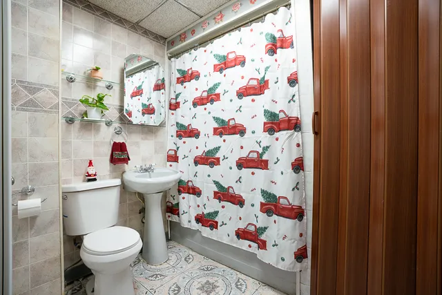 a bathroom with a sink toilet and shower curtain
