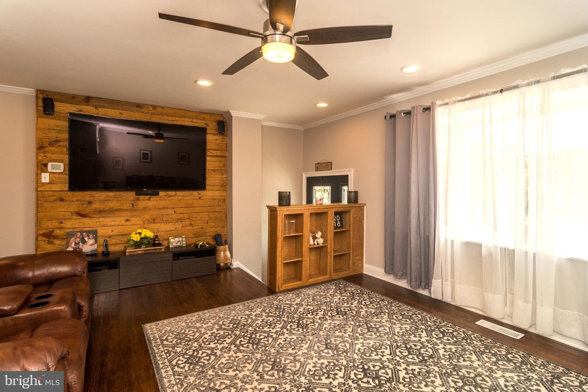 Living room with wood accent wall, wood floors