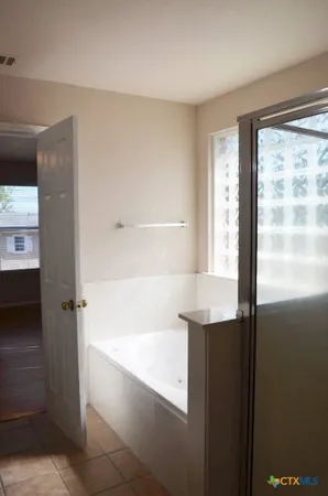 a view of a livingroom with a ceiling fan window and wooden floor