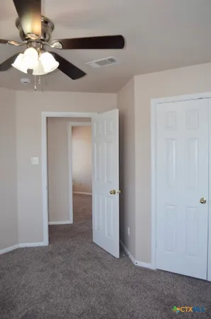 a view of an empty room with closet and entryway