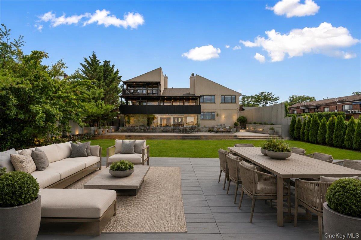 154-43 Riverside Drive Queens, NY 11357 - Photo 1 of 41 a view of a patio with couches table and chairs with potted plants and palm trees