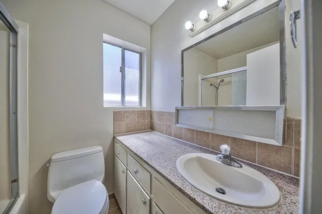 a bathroom with a toilet a sink and mirror