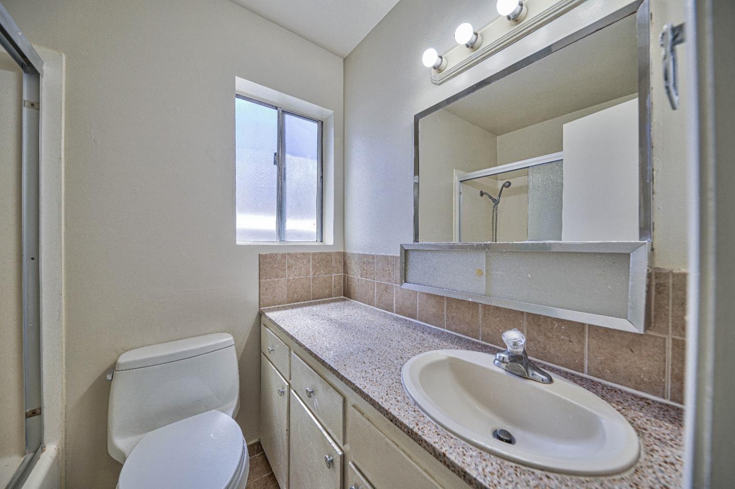 830 Parcel Street Monterey, CA 93940 - Photo 14 of 18 a bathroom with a toilet a sink and mirror